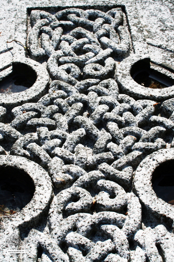 Closeup photo of an intricate celtic cross gravestone