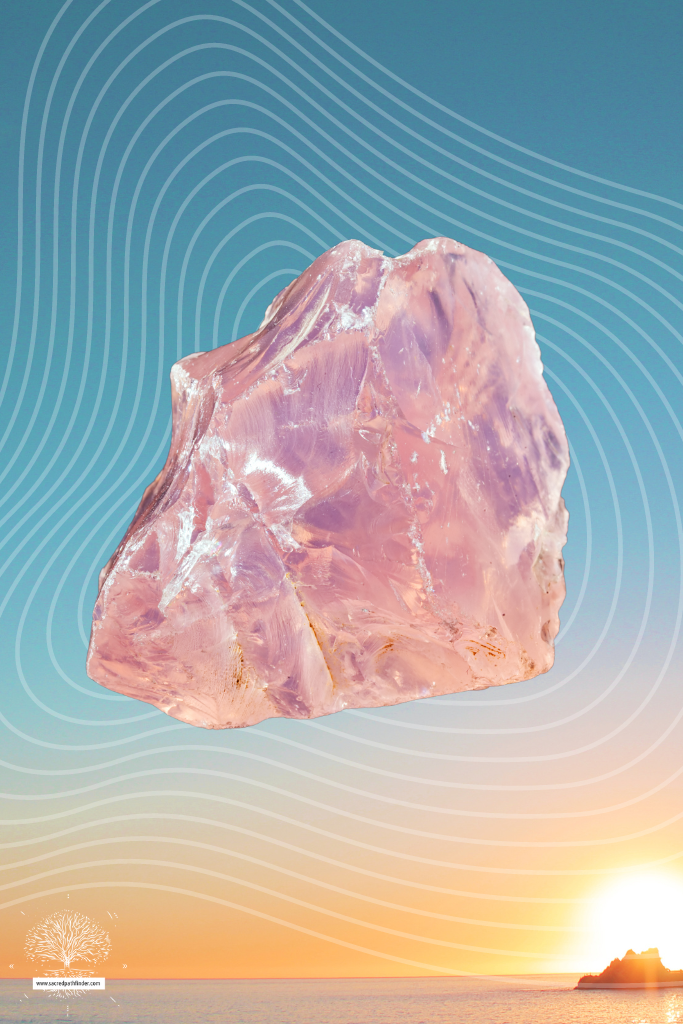 Photo of a rose quartz crystal in front of a sunset background.