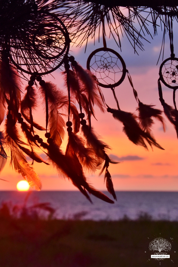 Photo of a sunset with multiple dreamcatchers blowing in the breeze.