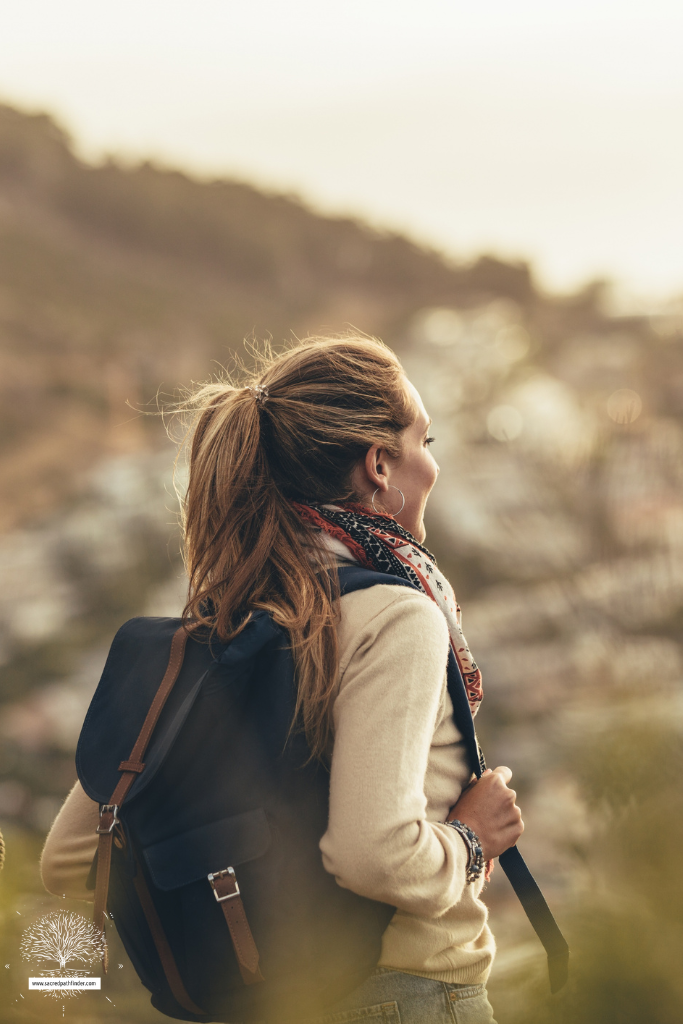 Photo of the back of a woman on a hike, in nature.