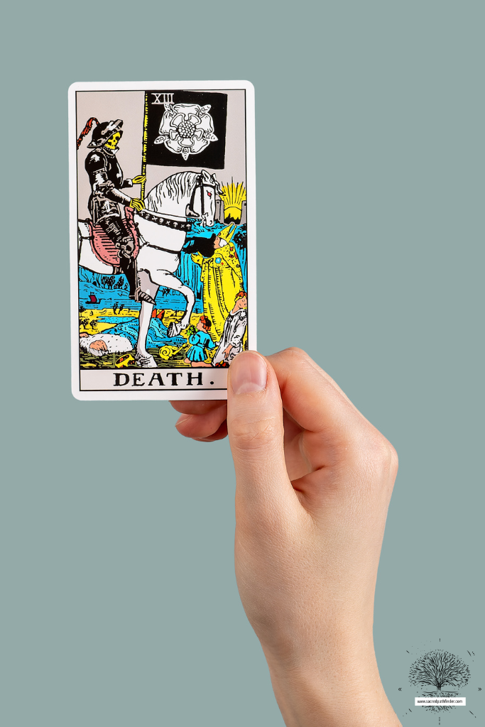 Photo of a hand holding up the Death tarot card. 