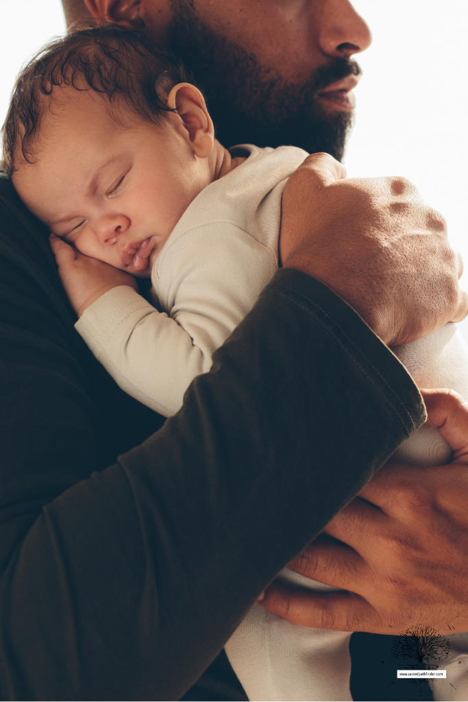 Photo of a dad holding his sleeping baby boy. 