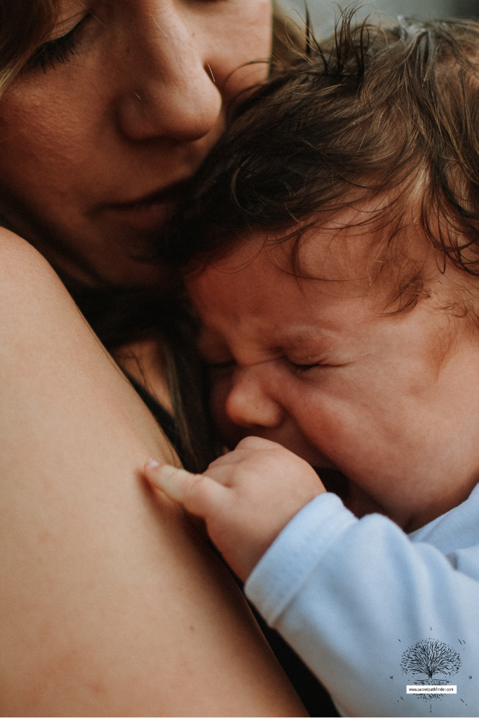 Photo of a mother holding a baby boy, who is crying.