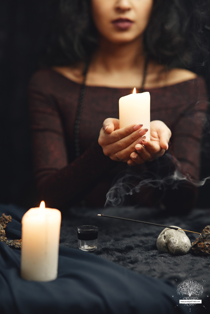 Photo of a woman holding a candle and lighting incense, performing a ritual.