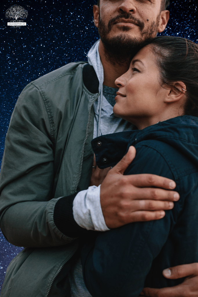 Photo of a couple, hugging and looking happy. The background is a starry night sky. 